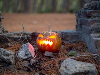 Calabaza de halloween con fuego en su interior en un bosque para celebrar el día de muertos o de...