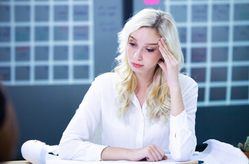 Sad depressed woman holding head in hands. Depressed business woman in employee meeting at sale marketing online office