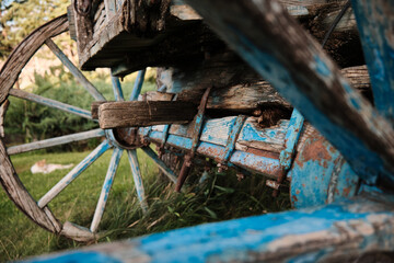 Vintage wooden carriage, wheel details. Rusty steel and blue painted old wood look. 