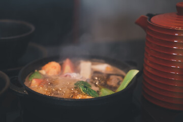 Japanese Sukiyaki with black soup in traditional cast iron pot