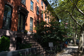 Fototapeta na wymiar Row of Old Brownstone Homes in Clinton Hill in Brooklyn of New York City along an Empty Sidewalk