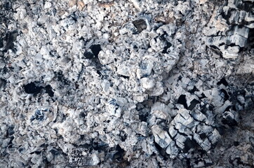 Coals in an extinct fire. Natural gray background. Coal and ash in a burnt fire