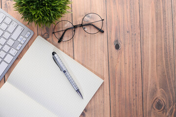 high angle view of open notepad with keyboard on table 