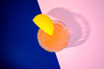 Orange colored drink with a slice of lemon