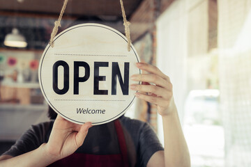 Reopen. barista or waitress woman turning open sign board on glass door in modern cafe coffee shop ready to service, cafe restaurant, retail store, small business owner, food and drink concept