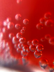 Extreme close up of bubbles in the red drink