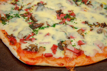 Pizza with mozzarella, fried mushrooms, sausage and parsley