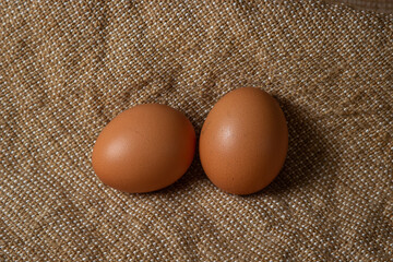 The eggs are on the sacking. Brown chicken eggs.