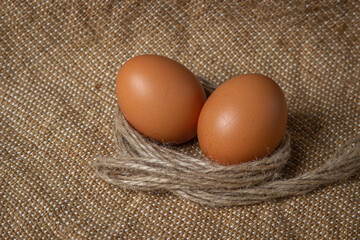 The eggs are on the sacking. Brown chicken eggs.