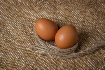 The eggs are on the sacking. Brown chicken eggs.