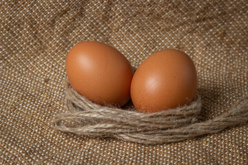 The eggs are on the sacking. Brown chicken eggs.