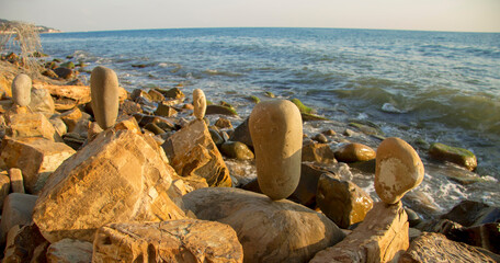 Balanced stones on the seashore summertime and sea background