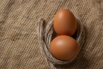 The eggs are on the sacking. Brown chicken eggs.