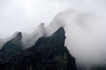 
The peaks of the High Tatras with white clouds. Mountains in the clouds. High Tatras Mountains in Slovakia