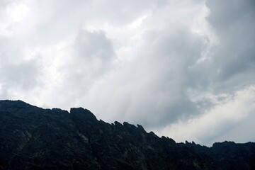 
The peaks of the High Tatras with white clouds. Mountains in the clouds. High Tatras Mountains in Slovakia