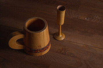 Wooden mug on a wooden table. Wooden dishes. Antique dishes.