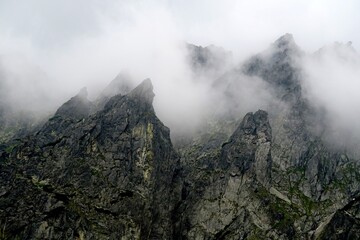 
The peaks of the High Tatras with white clouds. Mountains in the clouds. High Tatras Mountains in Slovakia