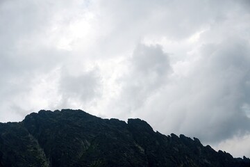 
The peaks of the High Tatras with white clouds. Mountains in the clouds. High Tatras Mountains in Slovakia
