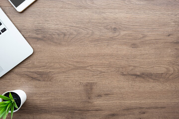 Wood office desk table with laptop computer and supplies. Top view with copy space, flat lay.