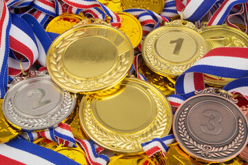Many gold, silver and bronze medals close up