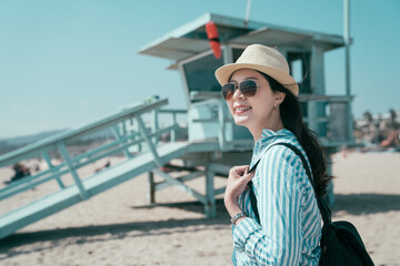 bokeh view lifeguard tower in Santa Monica on sunny day in California USA. happy smiling young girl...