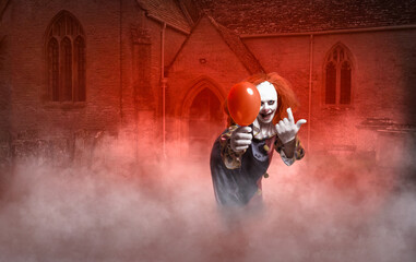 scary clown with a balloon in front of a church is luring the viewer