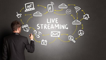 businessman drawing social media icons with LIVE STREAMING inscription, new media concept