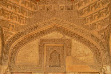A design inside of bara gumbad monument at lodi garden or lodhi gardens in a city park from the side of the lawn at winter foggy morning.