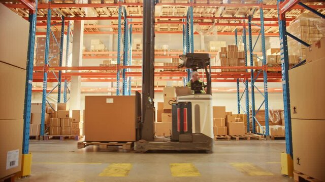 Retail Warehouse full of Shelves with Goods in Cardboard Boxes, Workers Scan and Sort Packages, Move Inventory with Pallet Trucks and Forklifts. Product Distribution Logistics Center. Dolly Shot