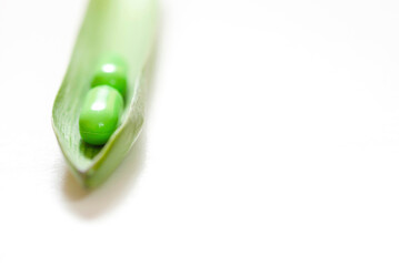 Green capsule with herb leaf on white
