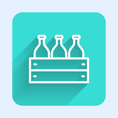 White line Bottles of wine in a wooden box icon isolated with long shadow. Wine bottles in a wooden crate icon. Green square button. Vector Illustration.