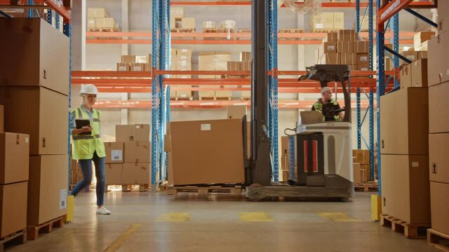 Retail Warehouse full of Shelves with Goods in Cardboard Boxes, Workers Scan and Sort Packages, Move Inventory with Pallet Trucks and Forklifts. Product Distribution Logistics Center. Dolly Shot