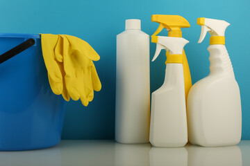 cleaning concept. spray bottle, bucket and rag on blue background