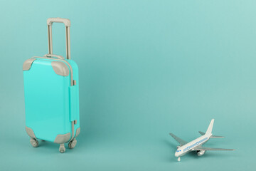 tourism concept with copy space. toy airplane and luggage on blue background