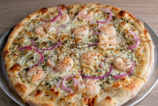 Gourmet pizza white pie with shrimp, red onion, caper & lemon.
