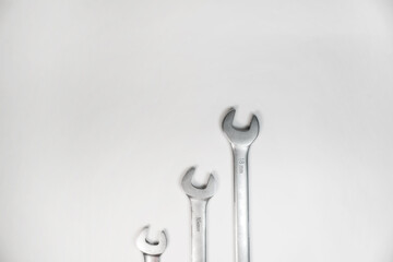 Three steel wrenches on a white background. Machine repair tools. Top view. Copy space
