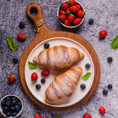 Breakfast with croissants and fresh fruits.
