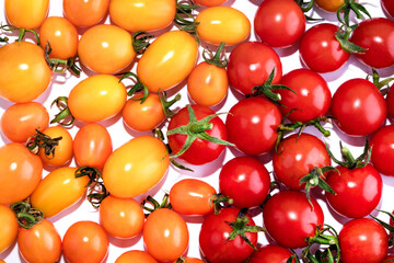 Red and yellow cherry tomatoes isolated on white background. Top view food background. Place for text