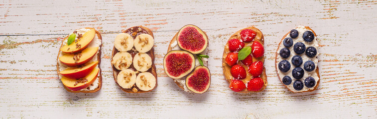 Homemade summer toast with cream cheese, nut butter and fruits and berries