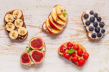 Homemade summer toast with cream cheese, nut butter and fruits and berries