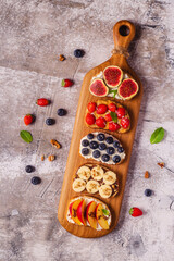 Homemade summer toast with cream cheese, nut butter and fruits and berries