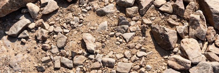 Panoramic image of the surface covered with big stones on the ground. The surface of the hiking trail. Top view