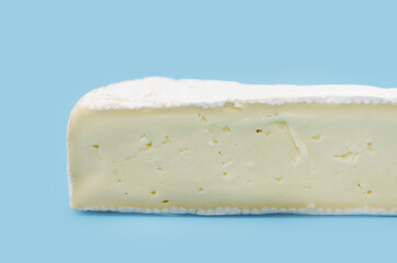 Close-up shot of brie cheese Isolated on blue background.