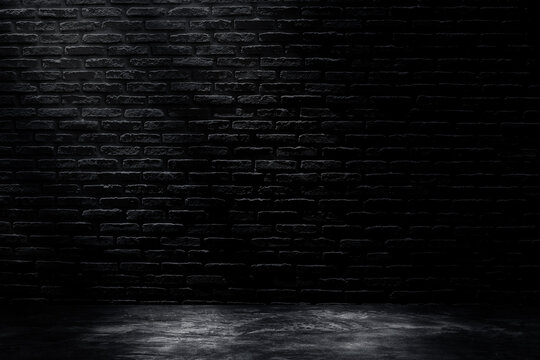 Studio dark room with black brick wall with concrete floor and lighting effect.