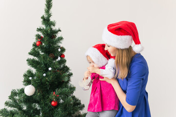 Fototapeta na wymiar Christmas concept - mother and her little daughter with Christmas tree at living room
