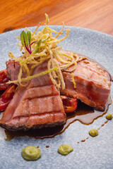 Tuna fillet on a parrilla with rostized jitomate in marmol plate. Gourmet tuna fillet