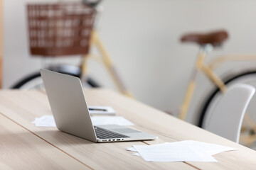 Empty office worker workplace without people, modern wooden table with laptop and paper documents,...