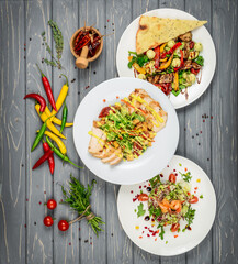 Food. Set of dishes salads on the table. On a wooden background.