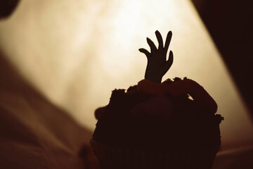 Zombie hands in chocolate muffin. Scary food banner. Worms in cake. Halloween party. Shadow...