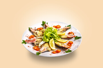 Shrimps, tomatoes and lemon are beautifully laid out on a dish on a black background.